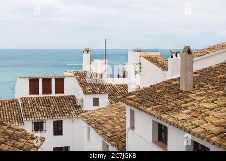 Vista su antichi tetti di tegole arancioni di case bianche e l'oceano nella città vecchia di Altea, Costa Blanca, Spagna Foto Stock