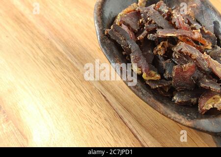 Ciotola ripiena di tradizionale biltong sudafricano su un legno superficie Foto Stock