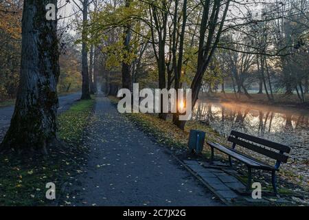 Umore d'autunno, alba, panca del parco, Rüstringer Stadtpark a Wilhelmshaven, bassa Sassonia, Foto Stock