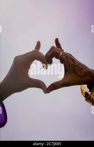 Un uomo e una donna che posano le mani come forma del cuore. Foto Stock