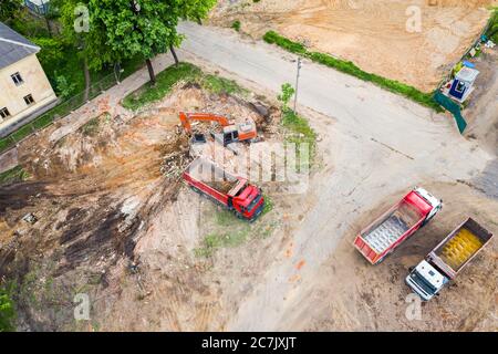 escavatore e dumper che lavorano in rovina nel cantiere. vista dall'alto Foto Stock