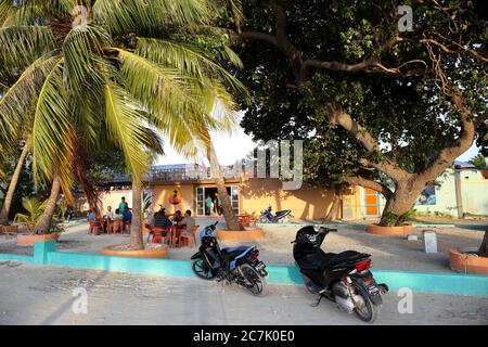 Maledives, Isla Maafushi, playa, palmeras, Gente en la calle Foto Stock