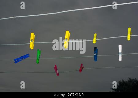Abiti colorati appesi alla corda con il cielo scuro sullo sfondo Foto Stock