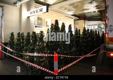 Gli alberi di Natale vengono consegnati in camion e lasciati all'ingresso del Pitt Street Mall al grande magazzino Myer di Sydney. Foto Stock