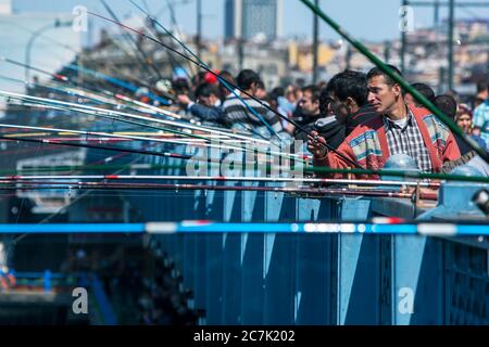 Centinaia di pescatori con i loro canne sono stabiliti sul ponte di Galata a Eminonu a Istanbul, in Turchia. Sperano di catturare il pesce del Corno d'Oro. Foto Stock