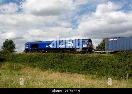 Locomotiva diesel di classe 66 in livrea marittima n. 66727 "maritime One" che traina un treno freightliner, Warwickshire, Regno Unito Foto Stock