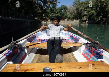 Un ragazzo curdo fila una barca intorno ad Ayn-i Zeliha, la seconda piscina sacra nel Parco Golbasi a Sanliurfa (Urfa) nella Turchia orientale. Foto Stock