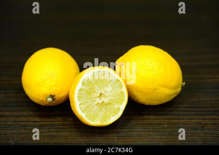 Colpo di closeup di tre limoni su una superficie di legno Foto Stock