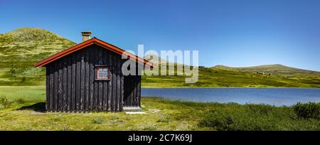 Capanna di tronchi vicino al lago nel Parco Nazionale di Rondane, Norvegia Foto Stock