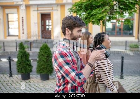 Nel profilo giovane ragazzo con macchina fotografica e due ragazze Foto Stock