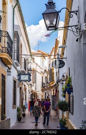 Ristoranti e negozi fiaccano la stretta e tortuosa Calle Cespedes di Cordoba mentre si snoda dalla storica moschea-cattedrale. Foto Stock