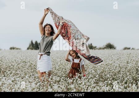 Famiglia felice all'aperto. Mother e figlia che camminano e in campo .Donna in un headscarf in sviluppo. Concetto di Livestyle Walking Foto Stock