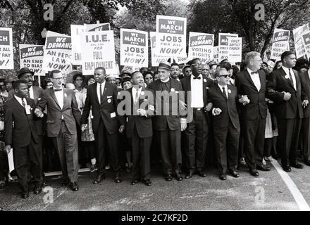 Il reverendo Dr. Martin Luther King, Jr, quarto da sinistra, e altri leader dei diritti civili tengono le mani mentre guidano una folla di centinaia di migliaia di persone alla marcia di Washington per il lavoro e la libertà, Washington DC, 28 agosto 1963. Da sinistra a destra: John Lewis, Mathew Ahmann, non identificato, Dr. Re, non identificato, non identificato, Rabbi Joachim Prinz, non identificato, e Whitney Young.Credit: Arnie Sachs/CNP | utilizzo in tutto il mondo Foto Stock