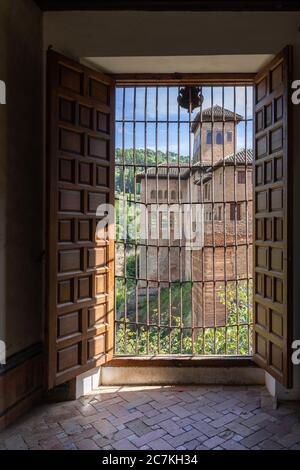 Una vista delle case moresche dell'Alhambra e della Torre de las Damas attraverso la porta nel cortile della Grille Foto Stock