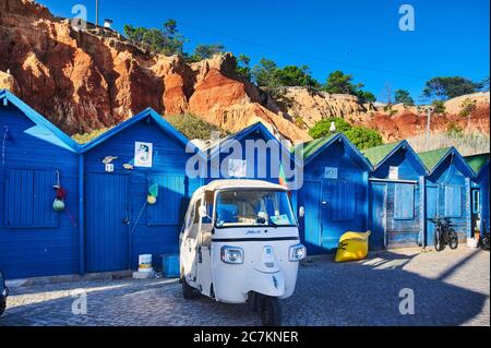 Europa, Portogallo, Algarve, Litoral, Barlavento, Faro District, Praia dos Olhos de Agua, capanne di pesca blu di fronte a una scogliera rossa con tuk Foto Stock