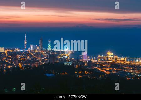 Batumi, Adjara, Georgia. Vista aerea del paesaggio urbano al tramonto. Città alla sera ora blu. Città in luci notturne Foto Stock