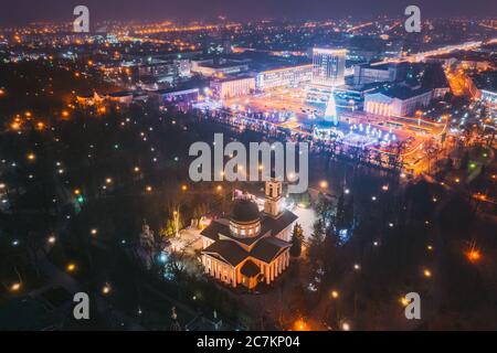 Gomel, Bielorussia. Albero di Natale principale e illuminazione festiva sulla piazza a Homel. Capodanno in Bielorussia. Vista aerea notturna. Pietro e Paolo Cattedrale in Foto Stock