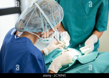 Team di chirurgia nella sala operatoria. Medico professionista che esegue la chirurgia Foto Stock