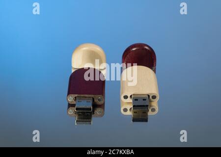 Due chiavette usb con cappuccio aperto in legno, fondo blu Foto Stock