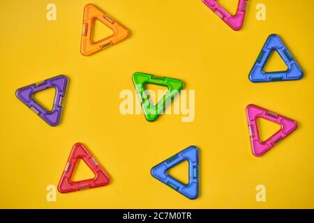 Vista dall'alto di colorati blocchi magnetici su sfondo giallo Foto Stock