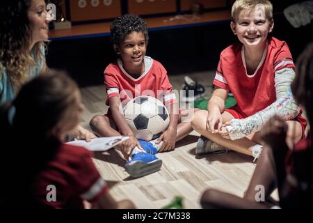 Giocatori di calcio e il loro allenatore spiegare prima di una partita. Foto Stock