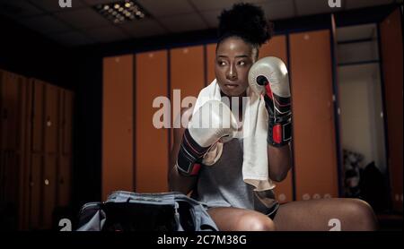 afroamericana boxe donna esercizio in formazione, giovane donna boxer indossare guanti per l'esercizio. Foto Stock