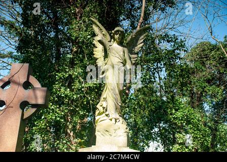 Foto ad angolo basso di una statua commemorativa di un angelo su un Tomba nel cimitero Nunhead di Londra in Inghilterra Foto Stock