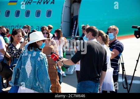 Kiev, Ucraina - 27 giugno 2020: I passeggeri saliscono a bordo dell'aereo. Persone mascherate salite a bordo del volo. Aeroporto Boryspil, aereo Windrose Airlines. Pista. Viaggi Foto Stock