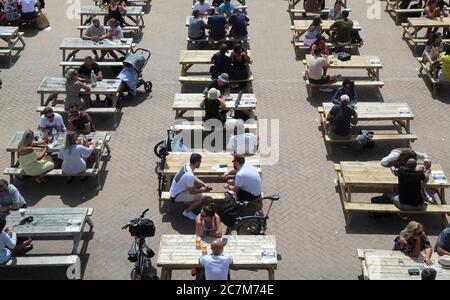 La gente può godersi i bar all'aperto durante il tempo soleggiato sulla spiaggia di Brighton. Foto Stock