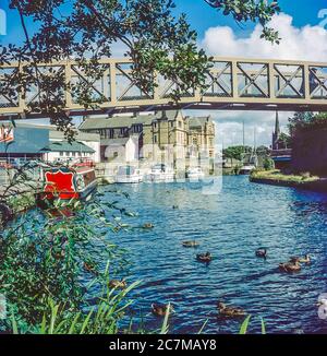 Questo è il canale Lancaster intorno al 1990 nella città nordoccidentale di Lancashire di Lancaster che serviva la regione nordoccidentale durante l'epoca vittoriana trasportando merci da Lancaster e Glasson Docks nord a Kendal e il centro ferroviario di Carnforth e sud a Preston per poi collegarsi con la rete transpare sistema di canali di pennine Leeds-Liverpool e rete di Manchester Foto Stock