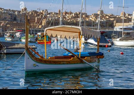 Romantica vista sul porto di Valetta e sulla tradizionale barca da pesca maltese con luzzu, Malta, EU. Foto Stock