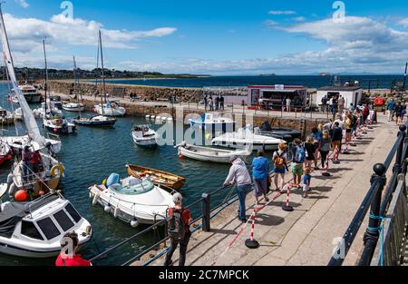 Lunga coda di persone socialmente distanziate per il prelievo di pesce di Lobster Shack durante la pandemia di Covid-19, porto di Berwick del Nord, East Lothian, Scozia, Regno Unito Foto Stock