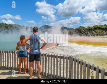 Coppia presso la Champagne Pool, sorgente termale presso il Wai-o-Tapu Thermal Wonderland, vicino a Rotorua, Nuova Zelanda Foto Stock