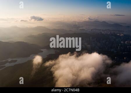 Affascinante scatto aereo del paesaggio urbano circondato dal verde sotto un cielo nuvoloso Foto Stock