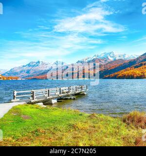 Molo in legno e vista fantastica sul lago Sils (Silsersee). Colorata scena autunnale delle Alpi svizzere. Località: Maloya, Engadina, Cantone Grigioni, Svizzera Foto Stock