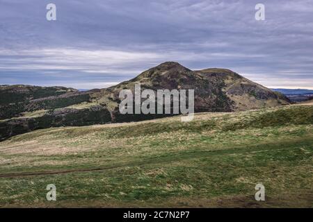 Vista con Arthurs Seat a Holyrood Park a Edimburgo, la capitale della Scozia, parte del Regno Unito Foto Stock