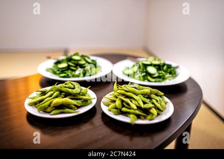 Vassoio di legno e pasto di insalata verde con edamame, cetrioli giapponesi e verdure di mizuna all'interno della casa in hotel ryokan o camera nazionale tata Foto Stock