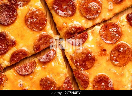 Pizza pepperoni fatta in casa, ricetta italiana. Vista dall'alto con deliziosa pizza. Pizza con salame e mozzarella da vicino. Foto Stock