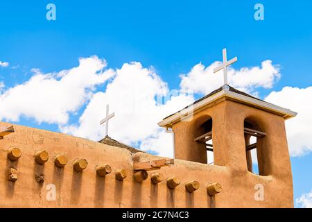 Ranchos de Taos closeup della chiesa di San Francisco de Aseis campanile con croce nel New Mexico basso angolo guardando verso il cielo blu Foto Stock