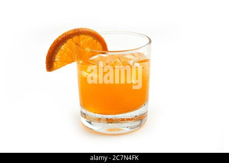 Limonata d'arancia con ghiaccio e fette di arancio fresco in un bicchiere trasparente su fondo bianco. Foto Stock