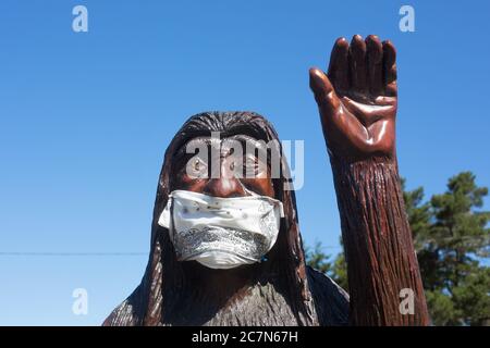 Una statua di bigfoot in legno intagliato con una maschera, a Firenze, Oregon, USA. Foto Stock