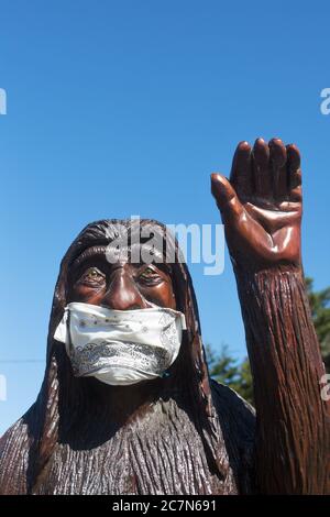 Una statua di bigfoot in legno intagliato con una maschera, a Firenze, Oregon, USA. Foto Stock