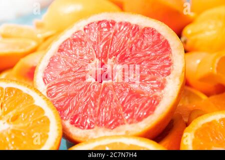 Pompelmo tagliato di fresco e fette di arancio con fondo di legno blu. Foto Stock