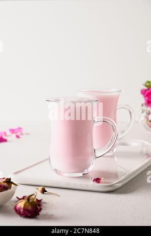 Latte di luna di rosa in bicchieri per dormire su sfondo bianco. Primo piano Foto Stock