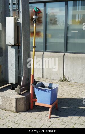 Attrezzatura per la pulizia e la pulizia a umido dei carrelli dei treni. Un secchio con soluzione di pulizia e disinfezione insieme a un mop si trova su una piattaforma ferroviaria. Foto Stock