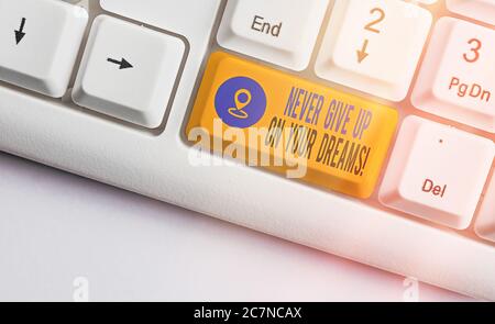Nota di scrittura che mostra mai non dare in su sui vostri sogni. Concetto di business per credere in te camminare il tasto tastiera colorata con accessori A. Foto Stock
