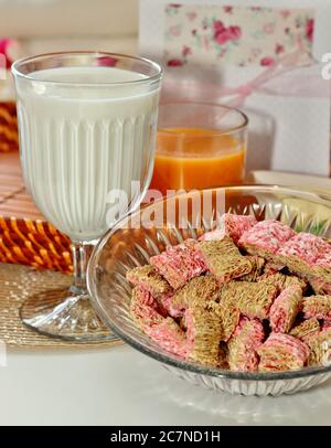 Ciotola di cereali con bicchieri di latte e succo Foto Stock