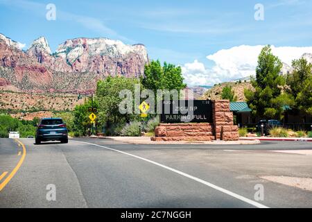 Springdale, USA - 5 agosto 2019: Cartello d'ingresso al Parco Nazionale di Zion con spazio per parcheggio completo sulla strada in Utah e auto nel punto di traffico stradale di vi Foto Stock