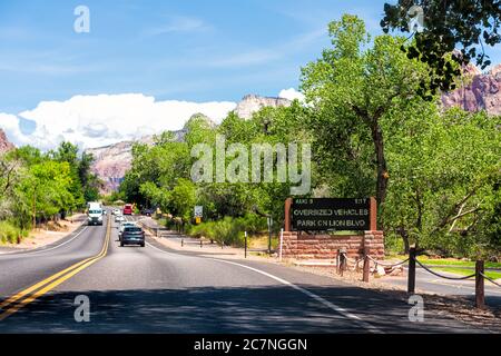Springdale, USA - 5 agosto 2019: Cartello d'ingresso e traffico del Parco Nazionale di Zion con informazioni sul parcheggio sulla strada in Utah e le auto nel punto di vista stradale Foto Stock