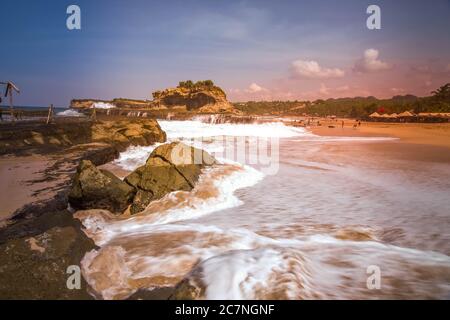 La bellezza di Klayar Beach con le sue pietre coralline uniche e gli alberi di cocco lungo la costa a Pacitan, Giava Est, Indonesia Foto Stock